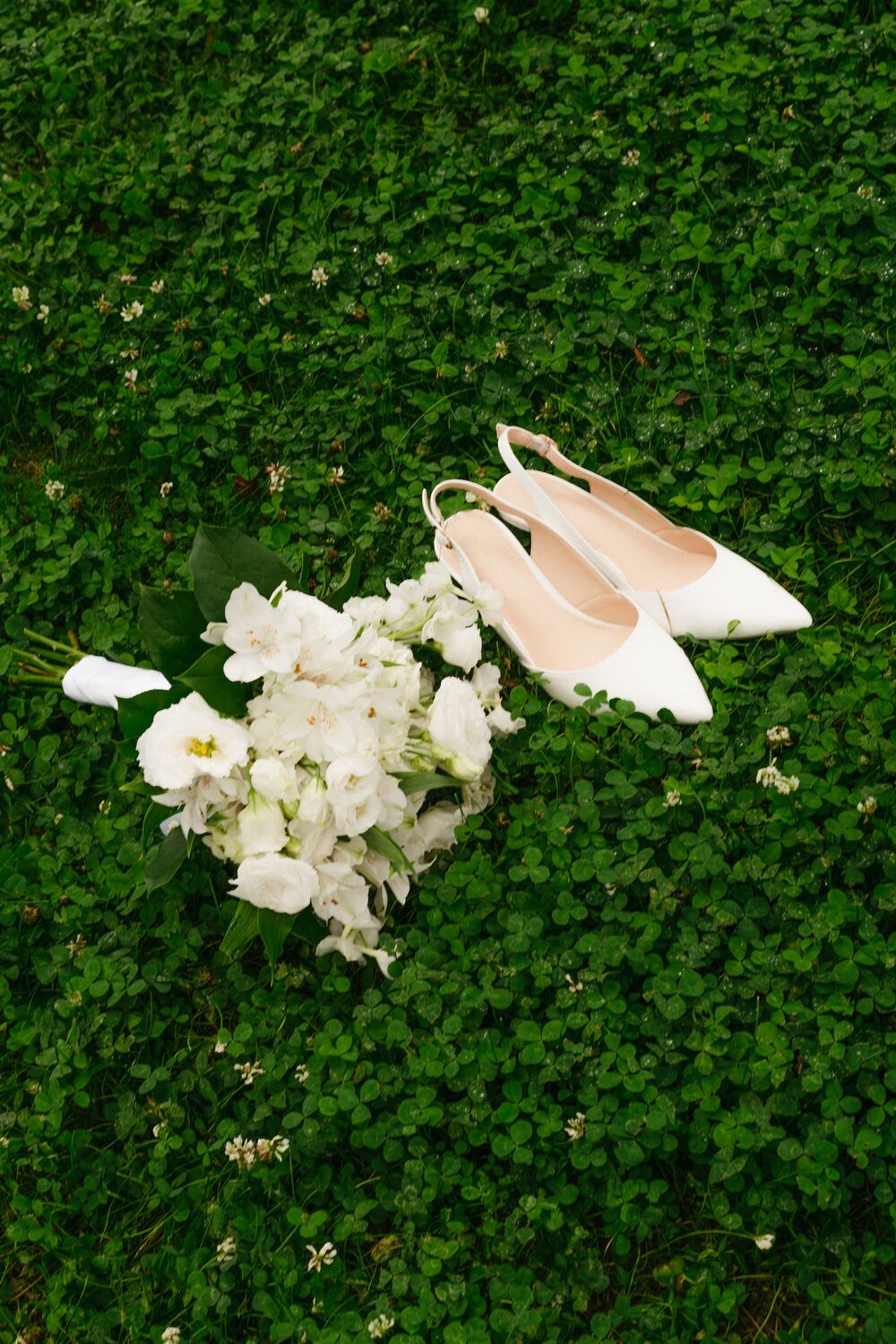 Bridal shoes and florals resting in the clover