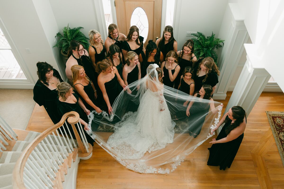 An overhead view of the bridesmaids gathered around the bride's flowing veil