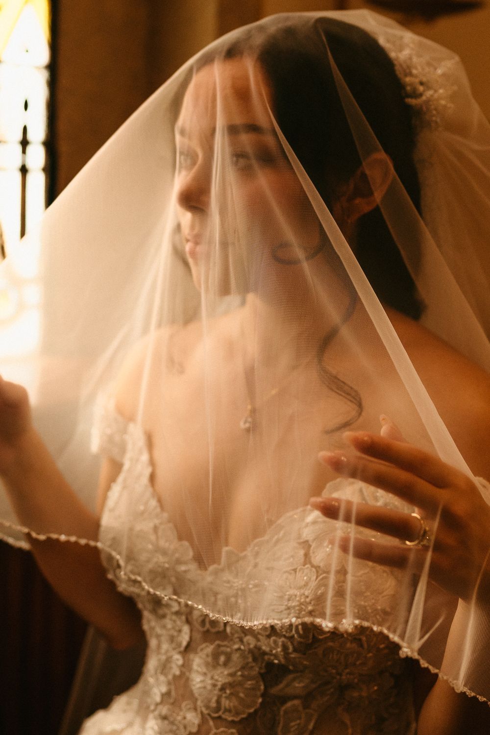 Brianna beneath her veil in warm window light