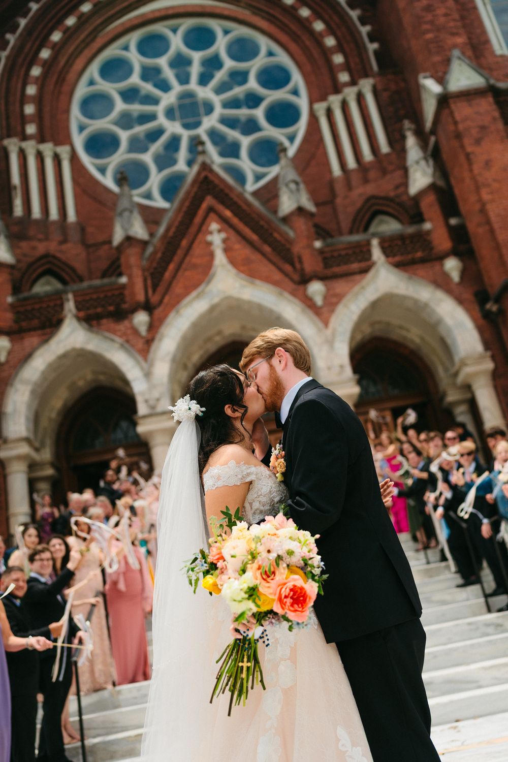 A kiss on the church steps beneath the rose window