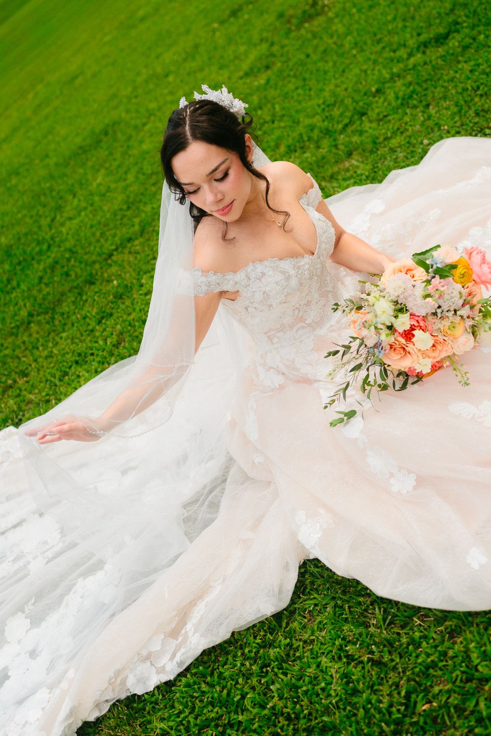 Brianna seated on the lawn, her gown spread around her