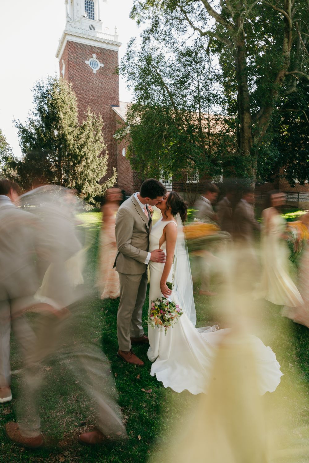 The wedding party celebrating in motion around the couple