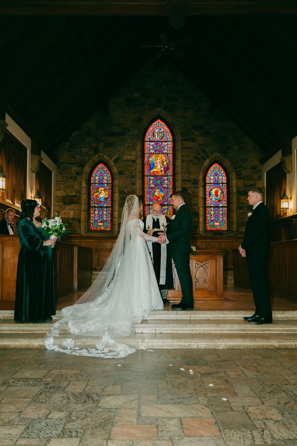 The ceremony in the stone chapel beneath stained glass