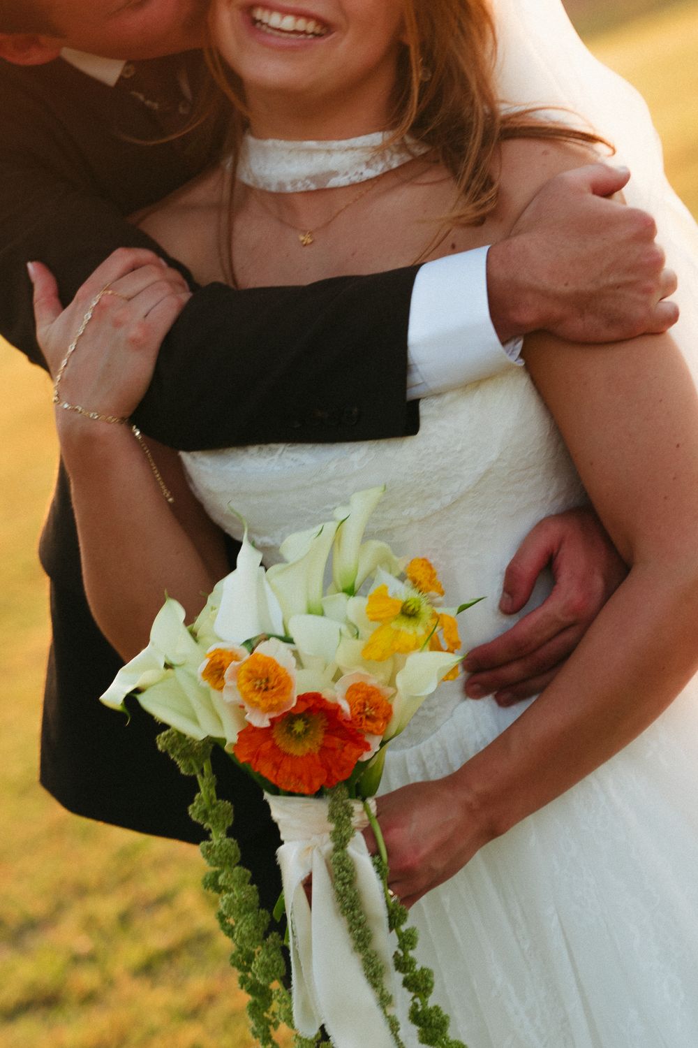 Close detail of the bouquet held at the bride's waist